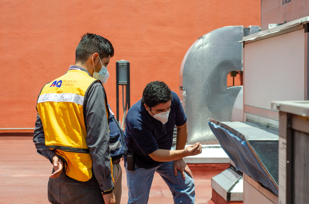 Técnicos de Air Quality de México realizando una inspección y mantenimiento en un sistema HVAC, asegurando la eficiencia y calidad del aire en instalaciones industriales