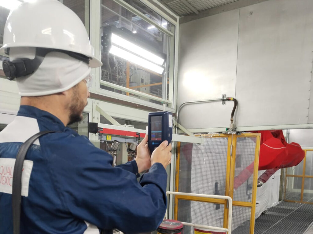Técnico de Air Quality de México realizando monitoreo de calidad del aire en un entorno industrial con equipo especializado, garantizando estándares óptimos en filtración.