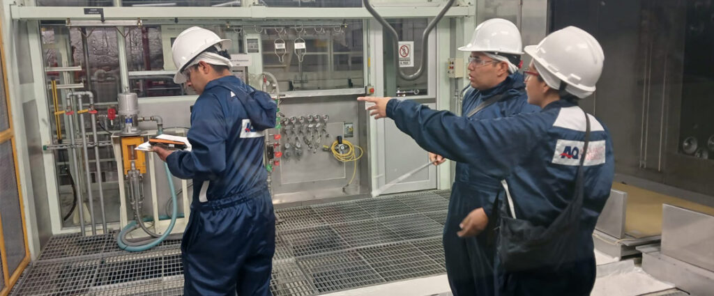 Equipo técnico de Air Quality de México evaluando sistema de filtración de aire en cabina de pintura automotriz, revisando flujo, conexiones y desempeño del sistema para mejorar la calidad del aire y el control de partículas en planta industrial.